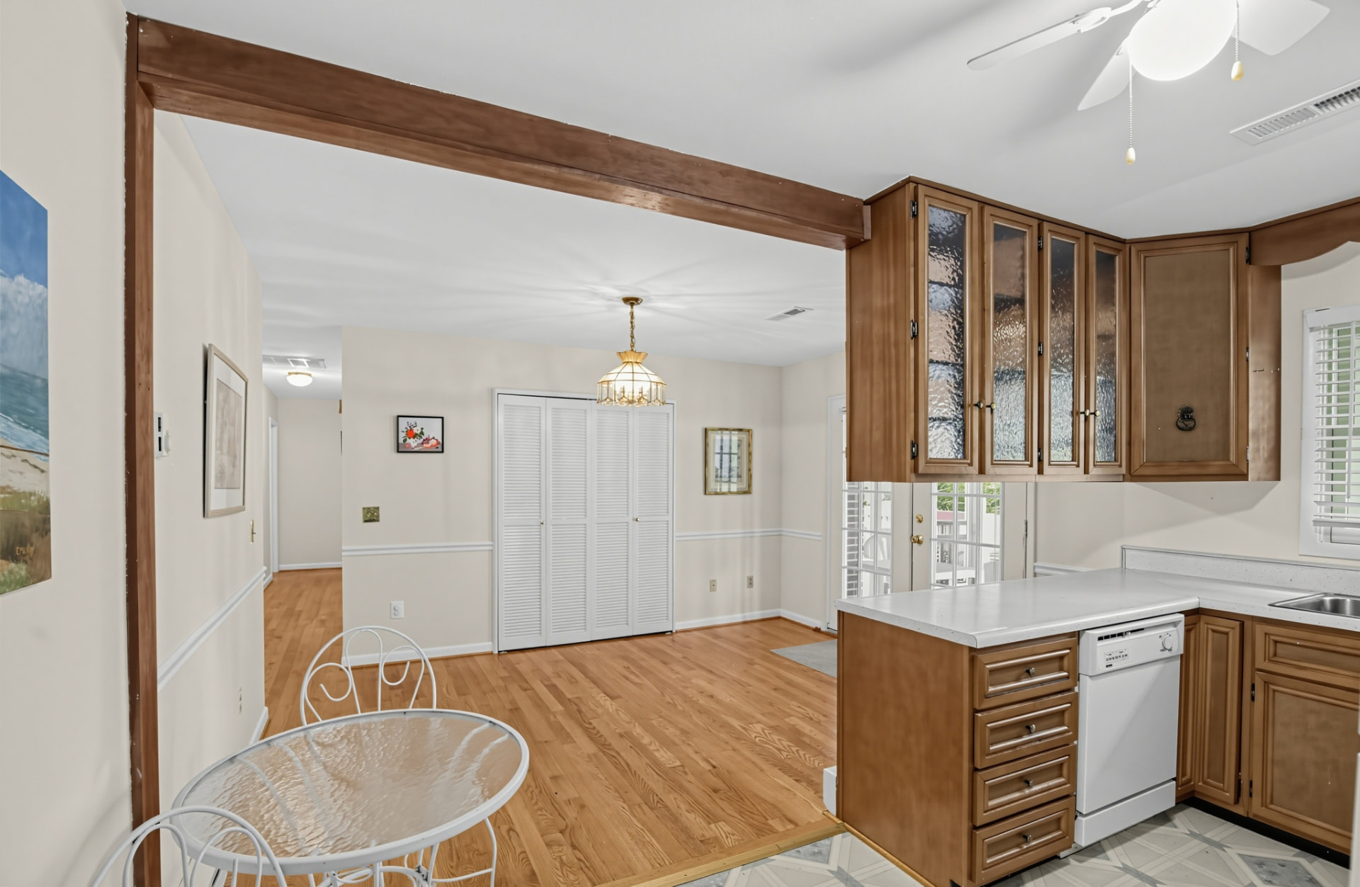 Kitchen with wood cabinetry opening to the dining area and hallway